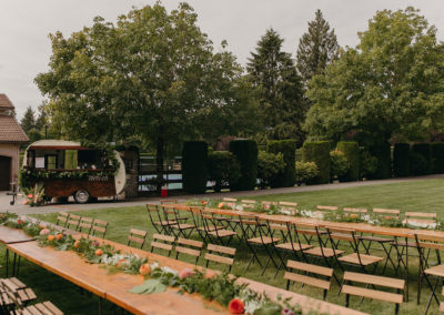 Rows_of_wood_tables_with_greenery_runners_event_rentals